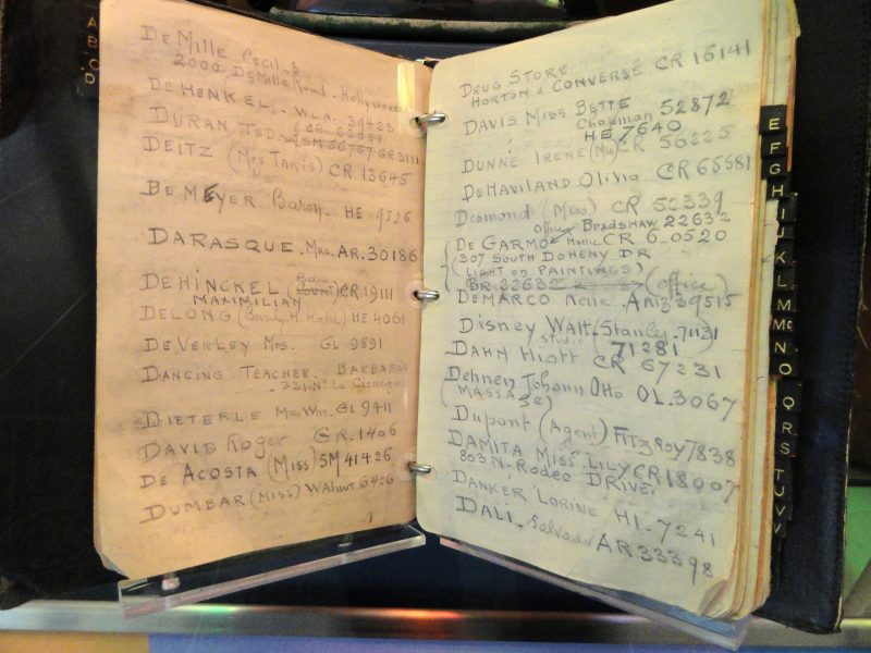 An old-fashioned address book, opened to the Ds, with many names and contact information written in in pencil. Some are famous, like Walt Disney.